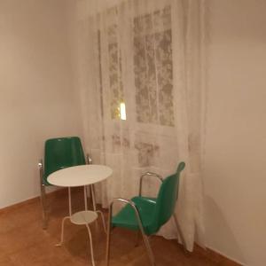 mesa y sillas en una habitación con ventana en Casa en Pinilla de Buitrago, en Gargantilla del Lozoya