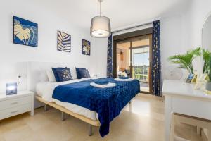 um quarto com uma cama com um edredão azul em Casares Costa Gem: 2BR with Pool em Bahia de Casares