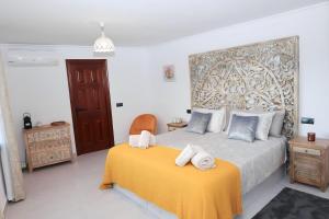 a bedroom with a bed with towels on a yellow blanket at La Pina Verde in Estepona