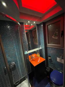 een badkamer met een wastafel en een douche met een rood plafond bij Barbara's appartment in Athene
