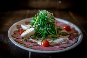 une assiette de denrées alimentaires contenant de la viande et des légumes sur une table dans l'établissement Vevey House, à Vevey