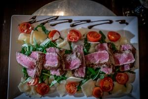 un piatto di cibo con carne e pomodori di Vevey House a Vevey