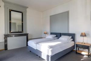 a bedroom with a large bed and a mirror at Vevey Hotel & Guesthouse in Vevey