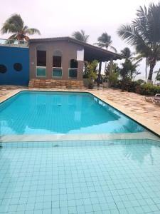 a swimming pool in front of a house at Marinas Tamandaré Flat in Tamandaré