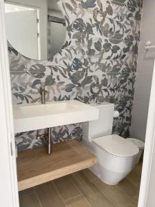 ein Badezimmer mit einem WC, einem Waschbecken und einem Spiegel in der Unterkunft Veuràs el Mar - Madrague Beach apartment 15 in Roses