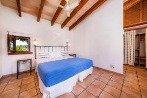 a bedroom with a bed with a blue comforter at Sa Rota den Palerm 3 in Lloret de Vistalegre