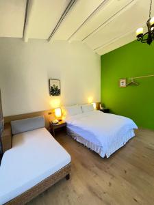 2 camas en una habitación con una pared verde en Alishan Tea Garden B&B en Fenchihu