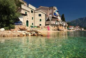 a building on the shore of a body of water at Apartments Ivica Mateljak in Brist