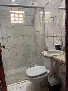 uma casa de banho com um chuveiro, um WC e um lavatório. em Elegância e Espaço. Casa Grande Individual em Palmas