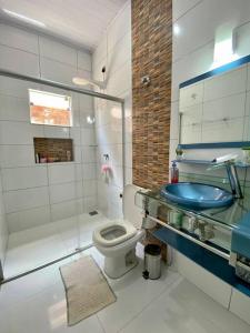 uma casa de banho com um chuveiro, um WC e um lavatório. em Elegância e Espaço. Casa Grande Individual em Palmas