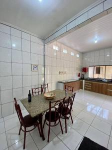 eine Küche mit einem Tisch und Stühlen im Zimmer in der Unterkunft Elegância e Espaço. Casa Grande Individual in Palmas
