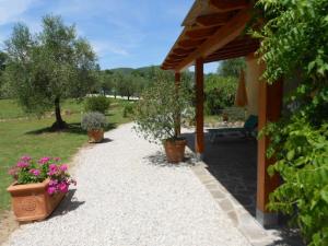 un camino con macetas y una casa en Casa Le Basse - Giuncarico, en Gavorrano