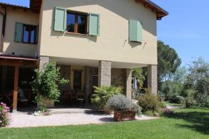 una casa con persianas verdes y un patio en Casa Le Basse - Giuncarico, en Gavorrano