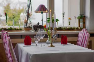 einen Tisch mit roten Servietten und Weingläsern darauf in der Unterkunft Hotel Weißes Schloß in Heringsdorf
