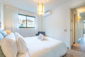 Un dormitorio con una cama blanca con dos animales de peluche. en Marsella, en Puerto de Sóller