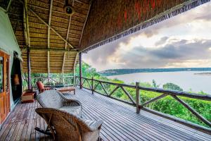 a porch with chairs and a view of the water at Mweya Safari Lodge in Katwe