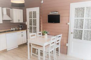 a kitchen with a white table and chairs and a tv at Maciejka in Rusinowo