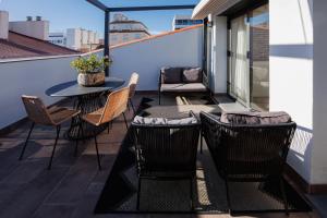 um pátio com uma mesa e cadeiras numa varanda em Atico duplex Playa Area barcelona con SPA exterior em Montgat