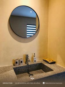 a bathroom with a sink with a mirror above it at Shelter Stay Da Nang in Da Nang