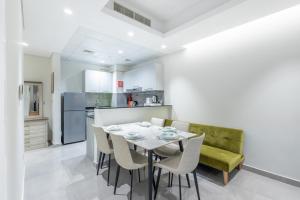 a kitchen and dining room with a table and chairs at SuperHost - Comfort 1BR Centurion Onyx Retreat with Balcony in Dubai