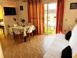 ガンディアにあるGandialco Playa de Gandiaのテーブルと椅子とベッドのあるダイニングルーム