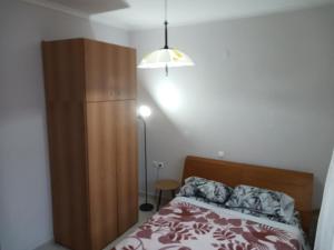 a bedroom with a bed and a wooden cabinet at APARTMENT MARIOS SOUFLI Ευρύχωρη γκαρσονιέρα, 60m2 στο κέντρο in Souflíon