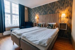um quarto de hotel com uma cama grande e uma janela em Hotell Vic Porsgrunn em Porsgrunn