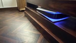 een houten dressoir met blauwe verlichting op een houten vloer bij Cinema Resorts 1 in Motobu