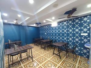 hotel nanda inn في حاريدوار: مطعم بطاولات خشبية وجدران زرقاء