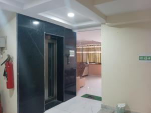a bathroom with a shower with a black wall at hotel nanda inn in Haridwār