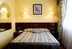 1 dormitorio con 1 cama y 2 lámparas en la pared en Hostal Centro Sol Madrid, en Madrid