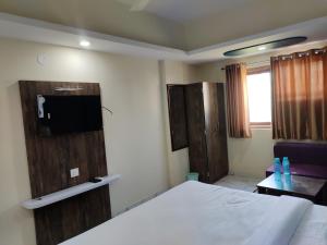 a hotel room with a bed and a tv at hotel nanda inn in Haridwār