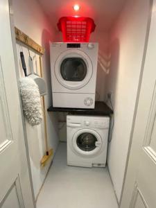 a washing machine with a red basket on top of it at Traditional Welsh cottage in Llanberis in Llanberis