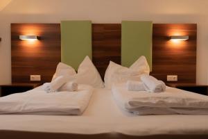 1 Schlafzimmer mit 2 Betten mit weißer Bettwäsche und Kissen in der Unterkunft Suite 1 - Krems an der Donau in Rossatz