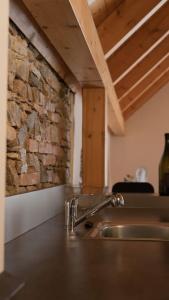 eine Küchentheke mit einer Spüle und einer Steinmauer in der Unterkunft Suite 1 - Krems an der Donau in Rossatz