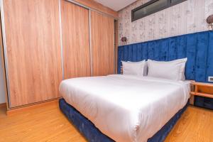 a large white bed in a room with wooden cabinets at Maarif elite suites in Casablanca