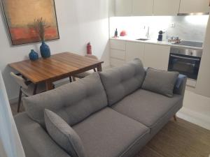 - un salon avec un canapé et une table en bois dans l'établissement Cais das Pedras Pátio Apartment, à Porto