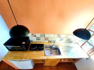 a kitchen with a sink and two black pendant lights at light-flooded apartment in the neighborhood in San Carlos de Bariloche
