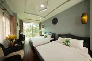 a hotel room with two beds and a window at Vintage Boutique Hotel & Spa in Ho Chi Minh City