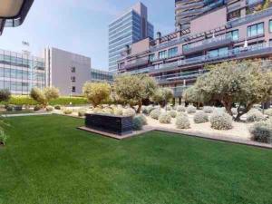 a park with a green lawn and a building at Apartamento Torre Australis in Madrid