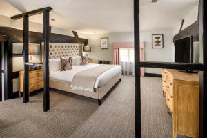 a bedroom with a bunk bed and a television at voco Lythe Hill Hotel & Spa, an IHG Hotel in Haslemere