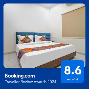 - une chambre avec un lit et des oreillers colorés dans l'établissement FabHotel Ramya, à Indore