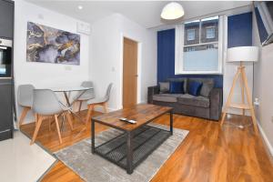 uma sala de estar com uma mesa e um sofá em Beautiful 1BR Apt for contractors in Stoke TV Wifi Washer em Stoke-on-Trent