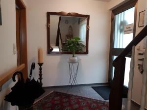 einen Flur mit Spiegel und Topfpflanze in der Unterkunft Ferienwohnungen Michael u Christine in Langenargen