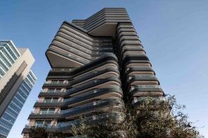 a tall building with a tree in front of it at Apartamento Torre Australis in Madrid