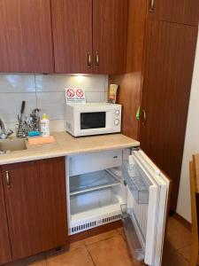 a kitchen with a microwave and an open refrigerator at Apartament Chopina 2 in Węgorzewo