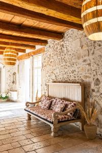 Bett in einem Zimmer mit einer Steinmauer in der Unterkunft Maison Bournissac in Noves