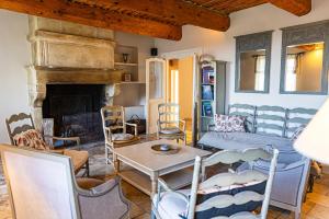 a living room with a fireplace and a table and chairs at Maison Bournissac in Noves