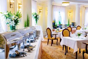 un comedor con mesas y sillas blancas y registradora en Pałacyk Otrębusy Business & Spa, en Otrębusy