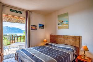 a bedroom with a bed and a balcony at Résidence Les Hameaux de Santa Giulia in Porto-Vecchio
